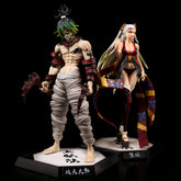 Displayed are two captivating anime figures on black bases. The left figure depicts a muscular character with green hair, tribal paint, and bandaged legs wielding axes. On the right is the 28CM Daki Demon Slayer Figure from Kimetsu no Yaiba by Demon Slayer, featuring long blonde hair, a bikini, and a colorful cape.