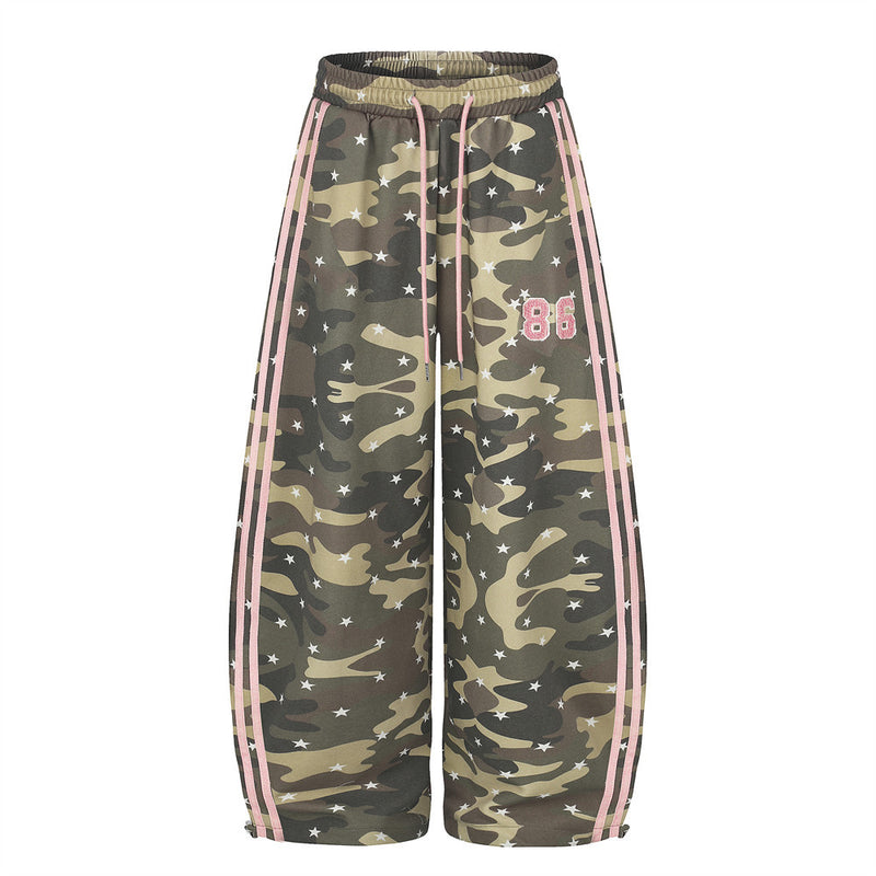 Front view of wide leg camo pants with pink side stripes, star print, and pink 86 patch