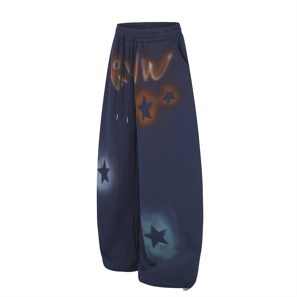 Navy wide leg sweatpants with star graffiti spray-dye shown angled front view