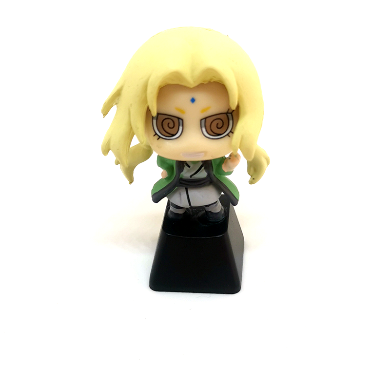 A small, stylized toy figure with long blonde hair stands on a black base resembling the vibrant hues of the Naruto Ninja Masters Keycap Set. It has large circular eyes and wears a green and light-colored outfit, reminiscent of cherished Naruto characters.