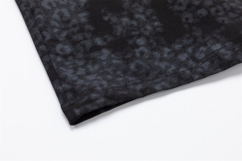 Close-up of the dark mottled shirt hem showing the folded edge and stitched finish
