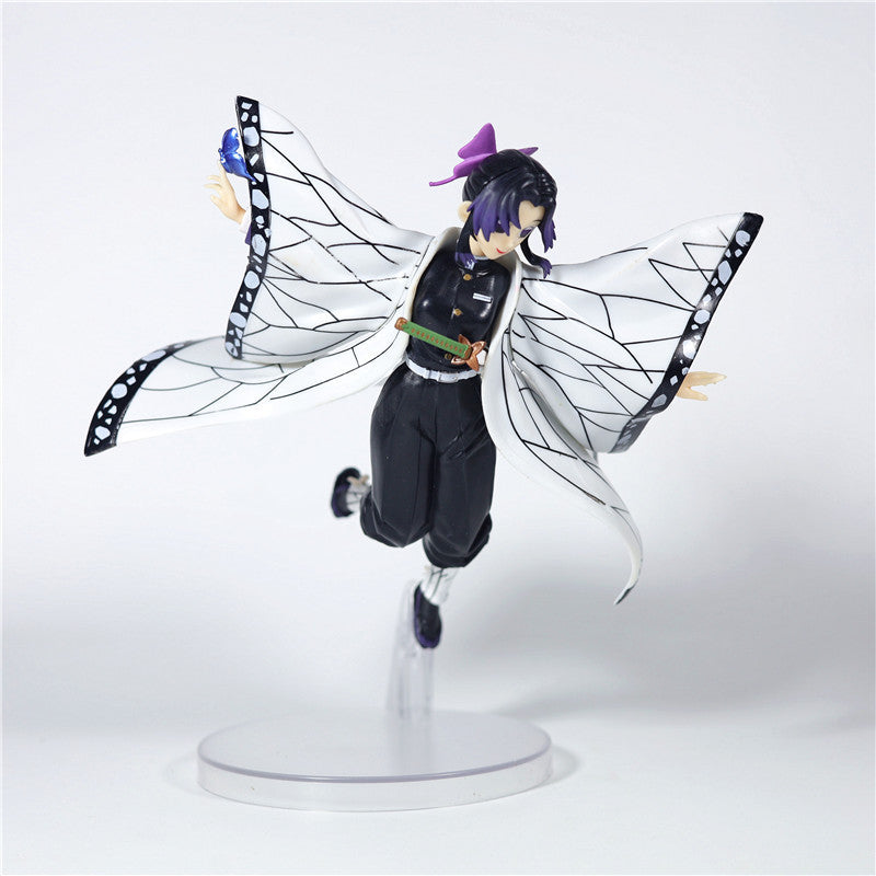 The Demon Slayer Shinobu Kocho Action Figure, a 15cm high-quality collectible, showcases her in a dynamic pose with outstretched arms and a detailed butterfly cloak. She features short dark hair accented by a purple ribbon and stands gracefully on a clear base, perfect for any anime figure collection.