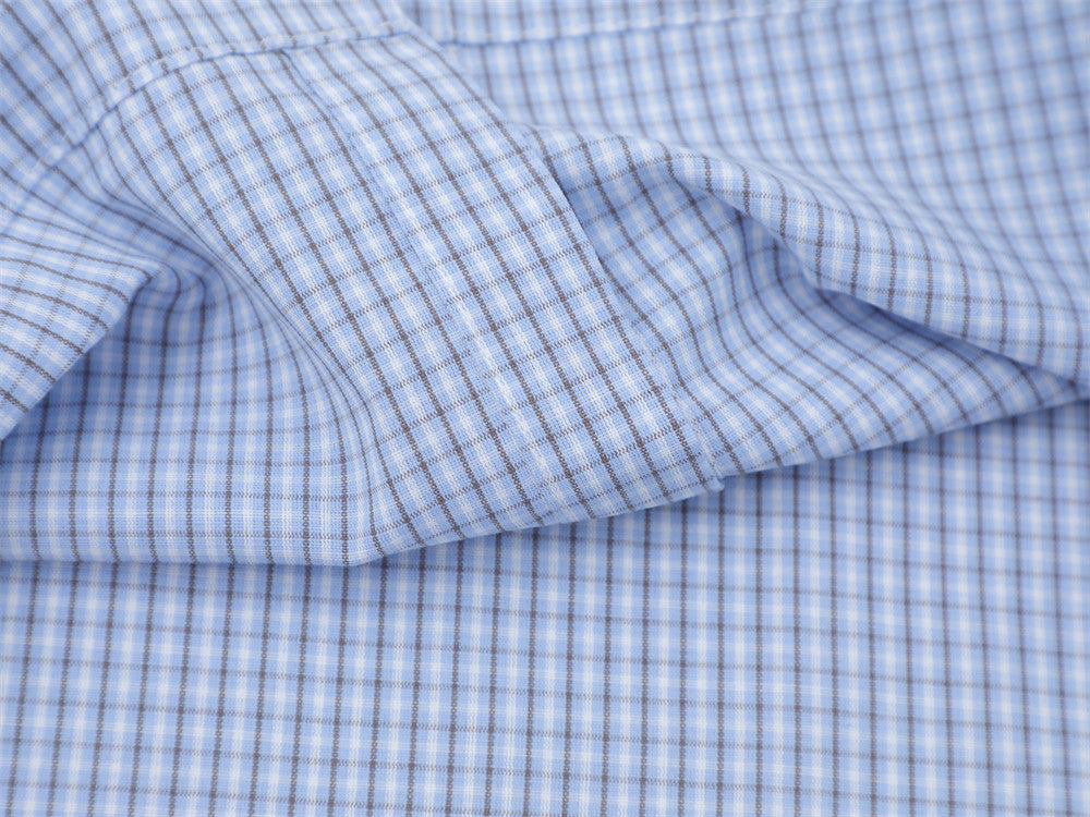Close-up of the light blue plaid shirt sleeve with contrast piping and gathered seam