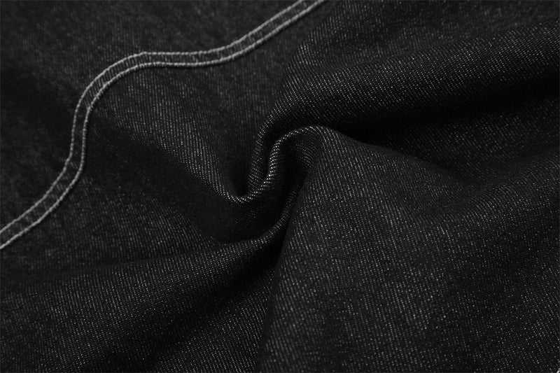 Close-up of black denim fabric texture with contrast seam stitching