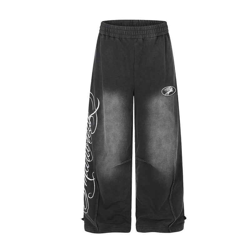 Pantalon de survêtement noir délavé coupe large, broderie script blanche et écusson ovale, vues avant et arrière