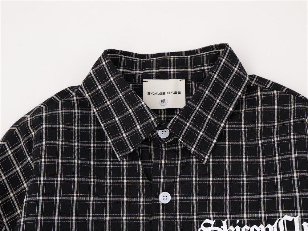 Close-up of black plaid shirt collar and button placket with woven label