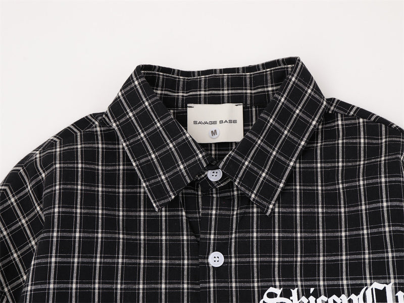 Close-up of black plaid shirt collar and button placket with woven label