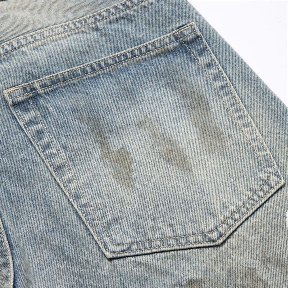 Close-up of back pocket on faded blue jeans with light paint stains