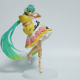 The Fairy Tale Sleeping Beauty Hatsune Miku 19cm PVC Figure features the beloved character with long teal hair, a white dress with pink roses, a yellow apron, balancing on one leg while holding a yellow pillow on a round base—perfect for Vocaloid fans seeking this charming collectible.