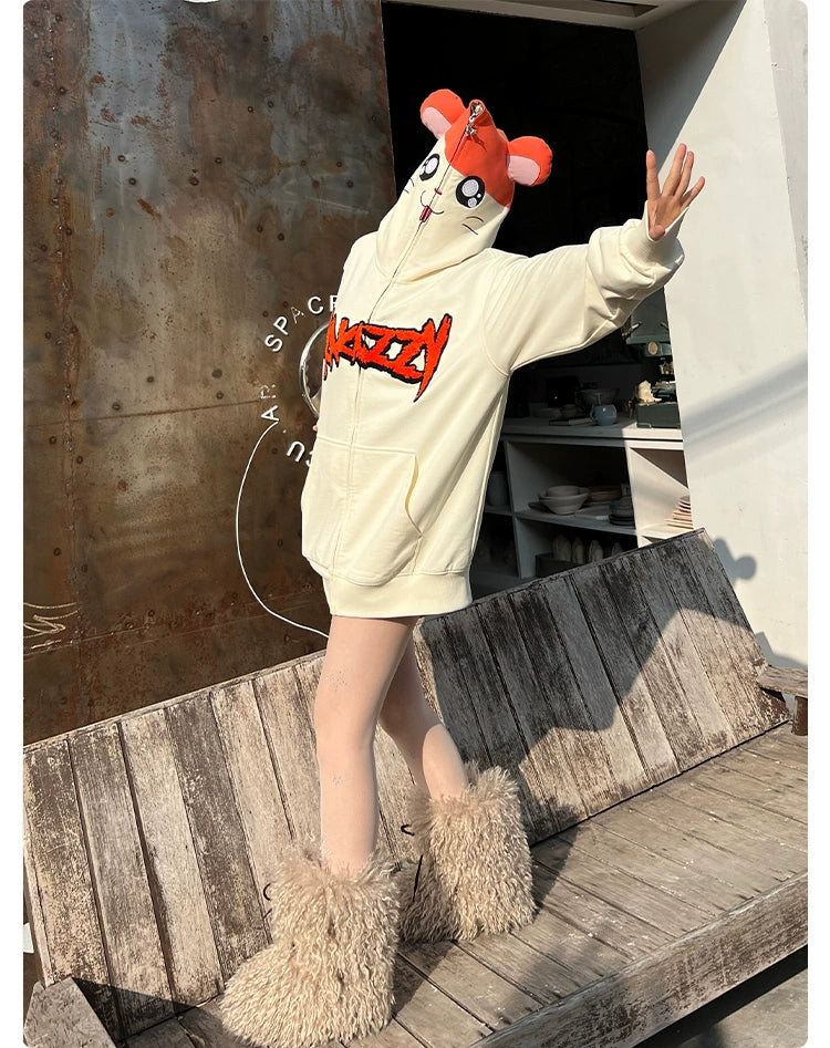 Wearing Seakoff’s Cute Hamster Cartoon Hoodie, featuring playful ears and fluffy boots, a person stands on a wooden bench with outstretched arms in front of a metal panel and bustling shelf—a perfect scene for cartoon lovers!.