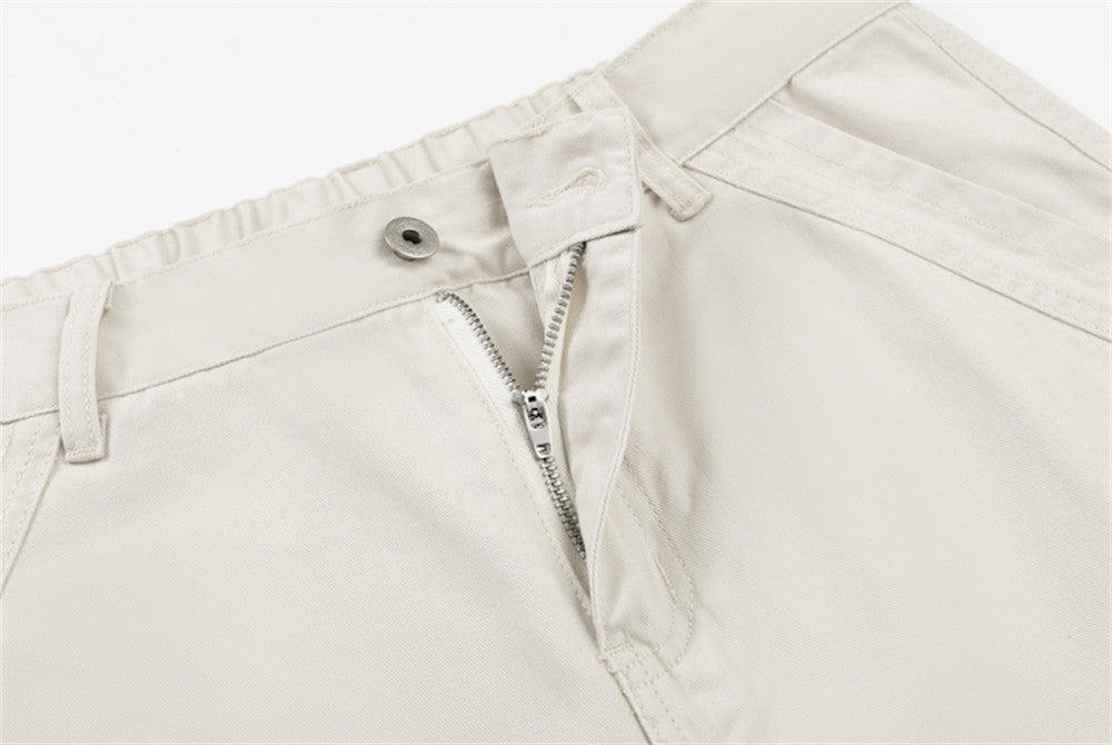 Close-up of cream pants front fly with zipper and button closure