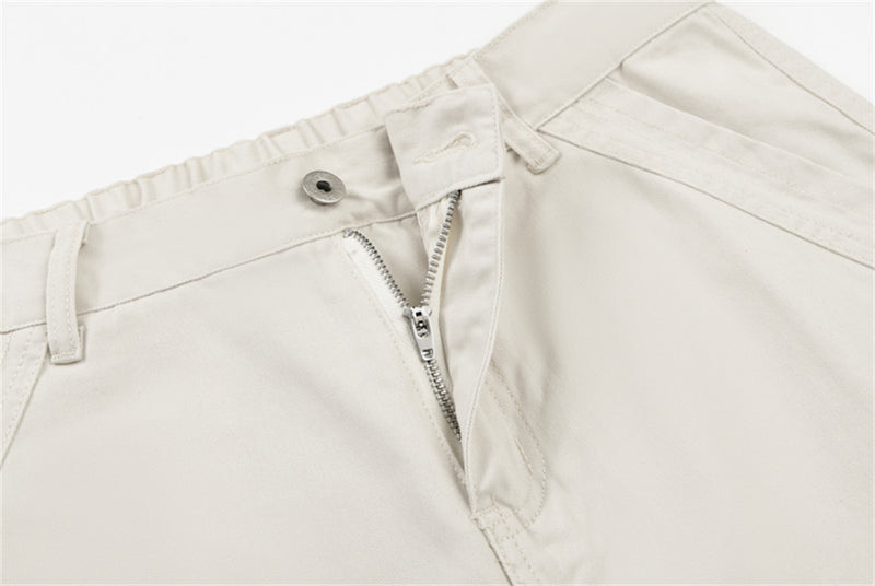 Close-up of cream pants front fly with zipper and button closure