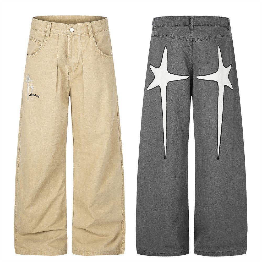 Wide-leg men's streetwear pants with star embroidery on front thigh and oversized cross graphic on back, shown in grey and be