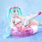 The Hatsune Miku Swimsuit with Float Ring 11cm PVC Figure features a turquoise-haired anime character, styled in a white and pink swimsuit, thigh-high socks, and goggles. She&