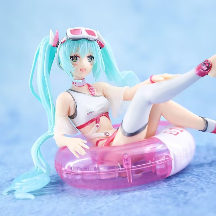 The Hatsune Miku Swimsuit with Float Ring 11cm PVC Figure features a turquoise-haired anime character, styled in a white and pink swimsuit, thigh-high socks, and goggles. She&