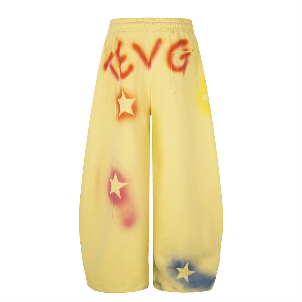 Yellow wide leg sweatpants with star graffiti spray-dye shown back view with pocket