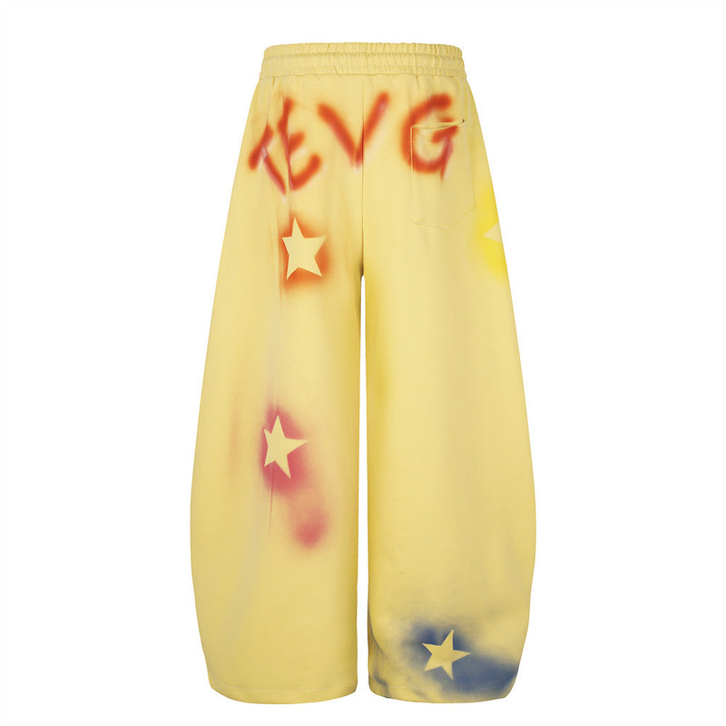 Yellow wide leg sweatpants with star graffiti spray-dye shown back view with pocket