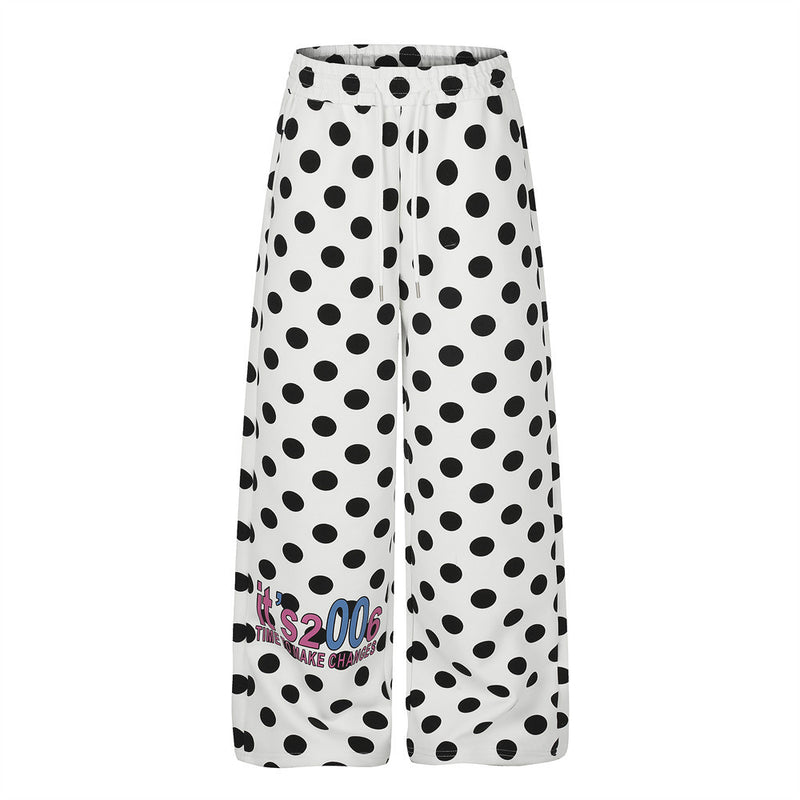 Pantalon de survêtement blanc à jambes larges, imprimé intégral à pois noirs et motif rétro coloré en lettres sur le bas de la jambe