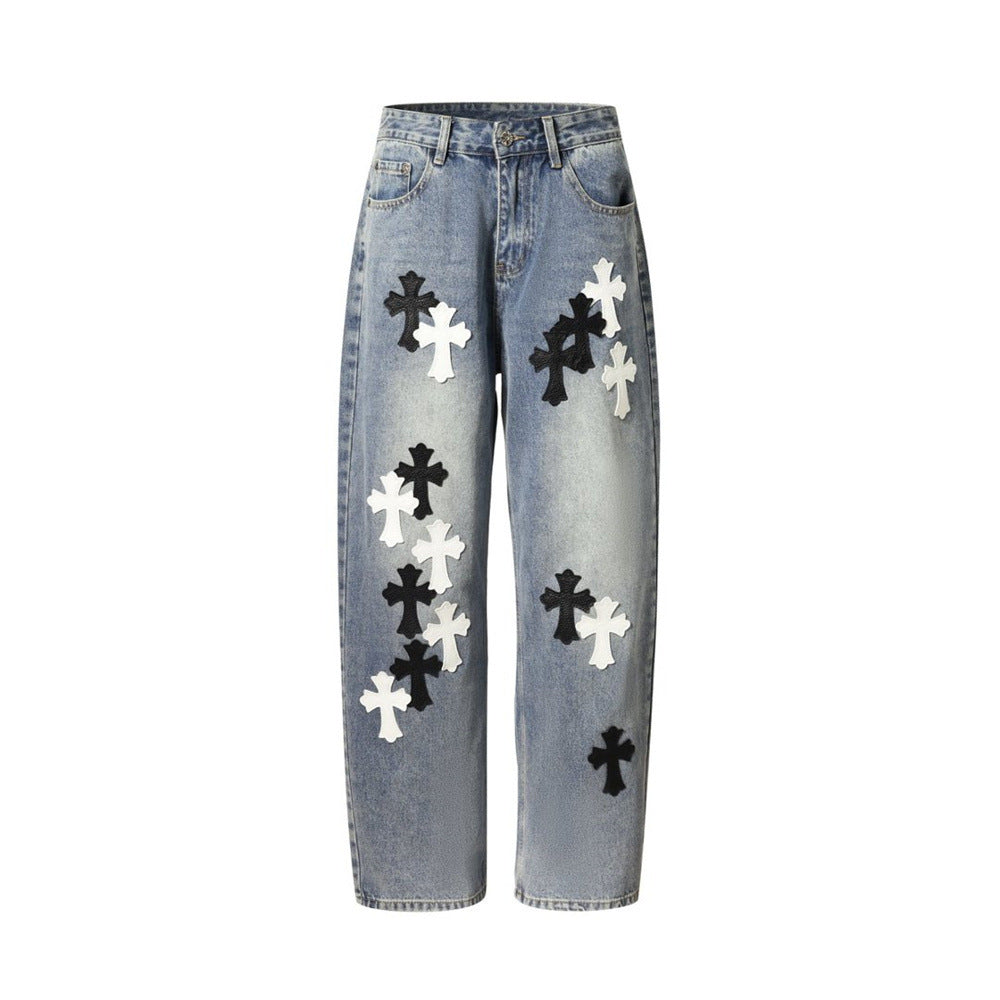 Light wash baggy jeans with black and white cross patches, front view