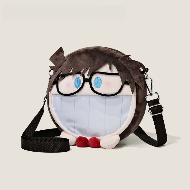 The Seakoff Detective Conan Edogawa Conan Plush Shoulder Bag is inspired by an animated character's face, featuring large glasses, blue eyes, a wide grin with a transparent mouth pocket, a brown plush exterior, adjustable black strap, and small red feet.