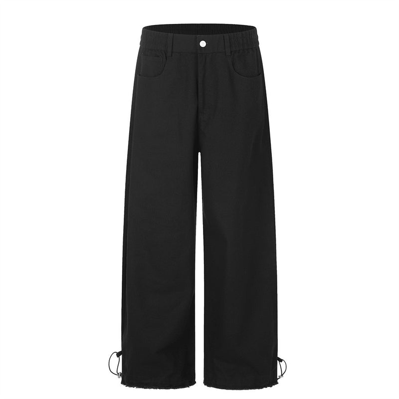 Men's wide-leg straight-cut pants in black with elastic waist, raw frayed hem, and drawstring ankle toggles