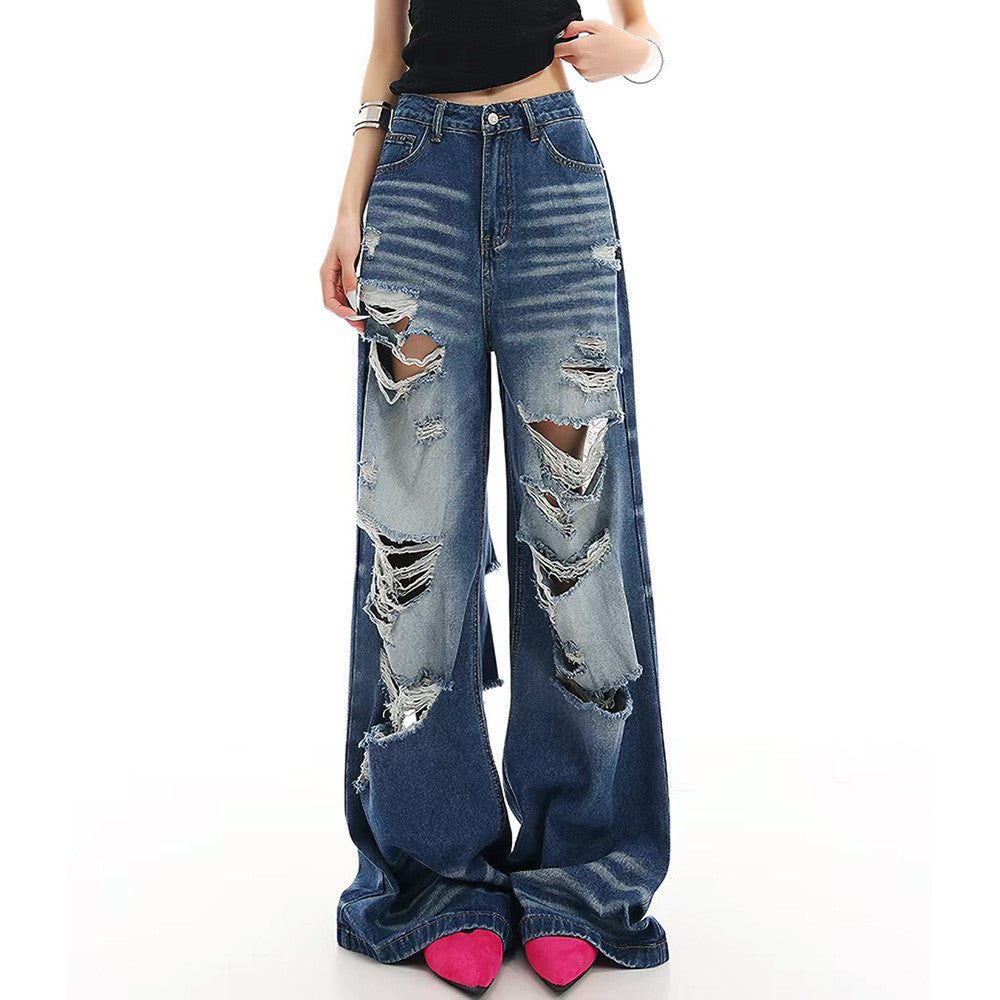 Men's baggy blue wide-leg distressed ripped denim jeans with heavy frayed rips on front and back panels