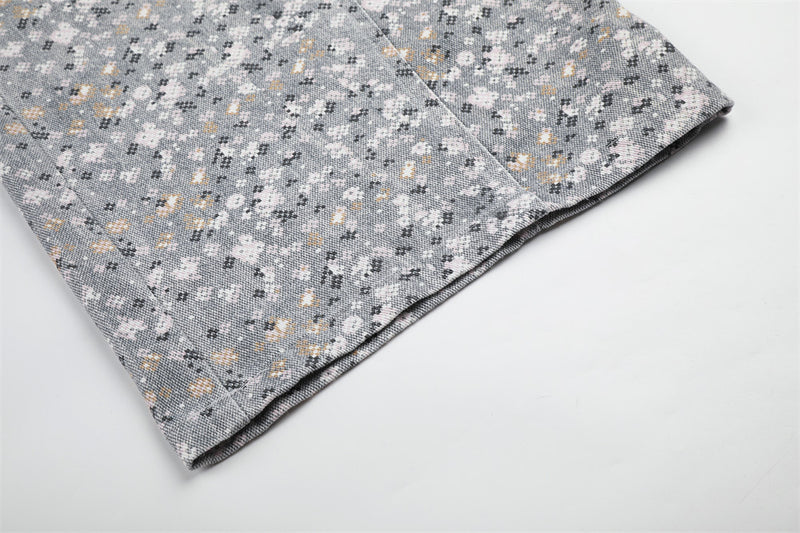 Close-up of wide-leg pant hem in gray mosaic floral print fabric