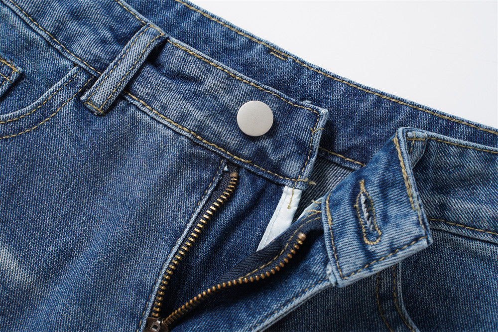 Close-up of front waistband with button and partially open zipper fly