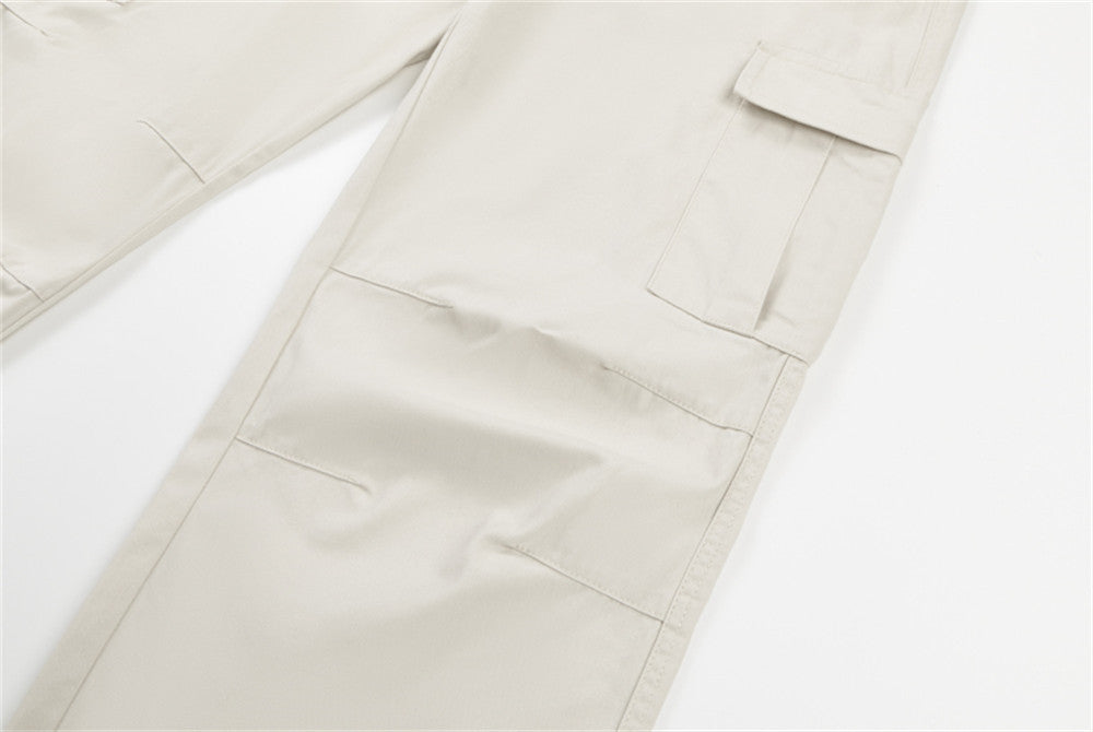 Close-up of cream cargo pants leg seam and pocket detail