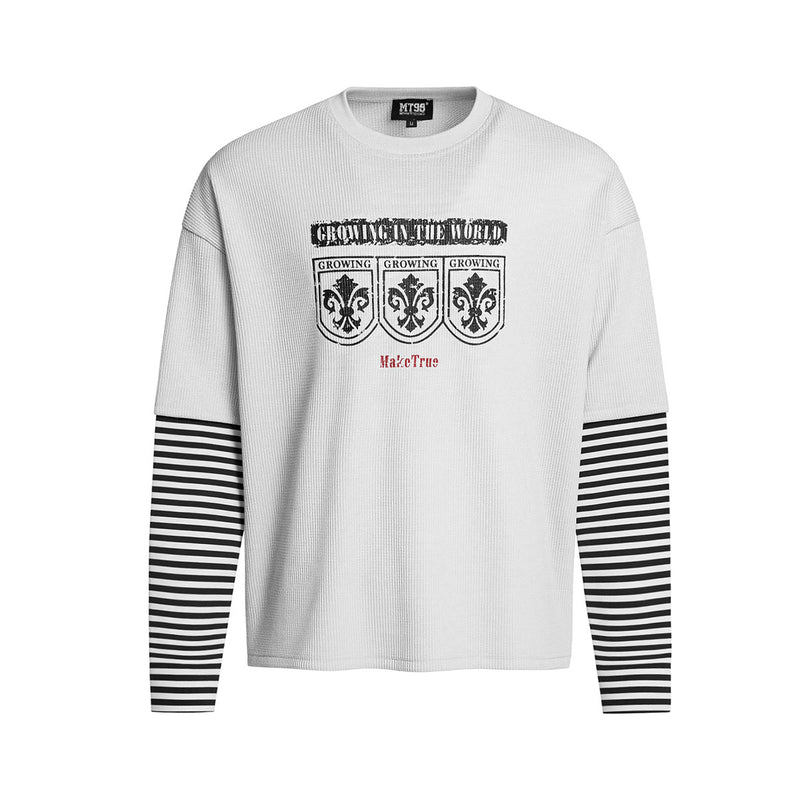 Oversized faux-layered long sleeve graphic shirt with black and white striped sleeves and heraldic crest print, shown in whit
