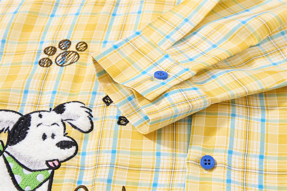 Close-up of sleeve cuff and front embroidery on yellow plaid shirt