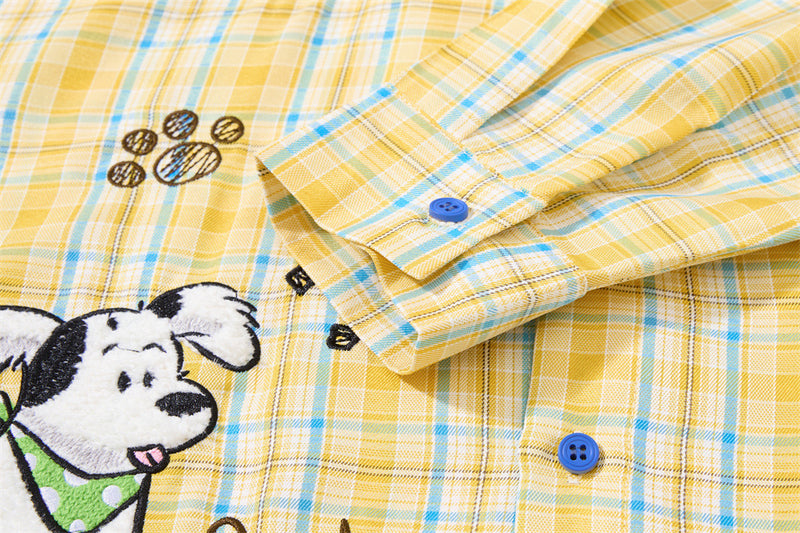 Close-up of sleeve cuff and front embroidery on yellow plaid shirt