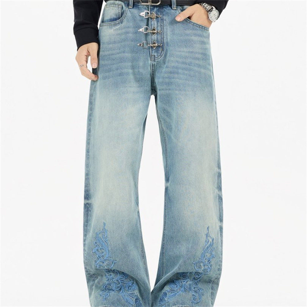 Men's light wash straight-leg jeans with blue floral vine embroidery at hem and decorative silver metal clasp fly closure