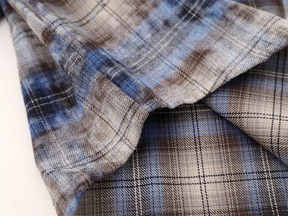 Close-up of shirt hem on blue plaid flannel with curved edge