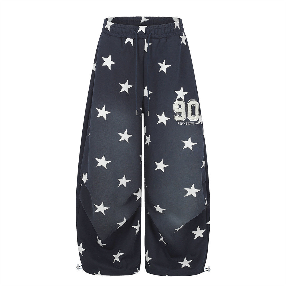 Oversized wide-leg star print sweatpants with pleated front panel and varsity 90 patch in navy blue