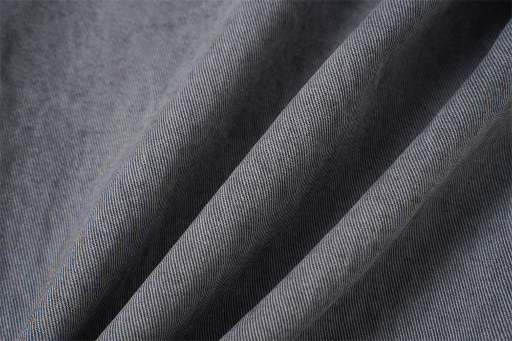 Close-up of grey denim fabric texture with soft folds