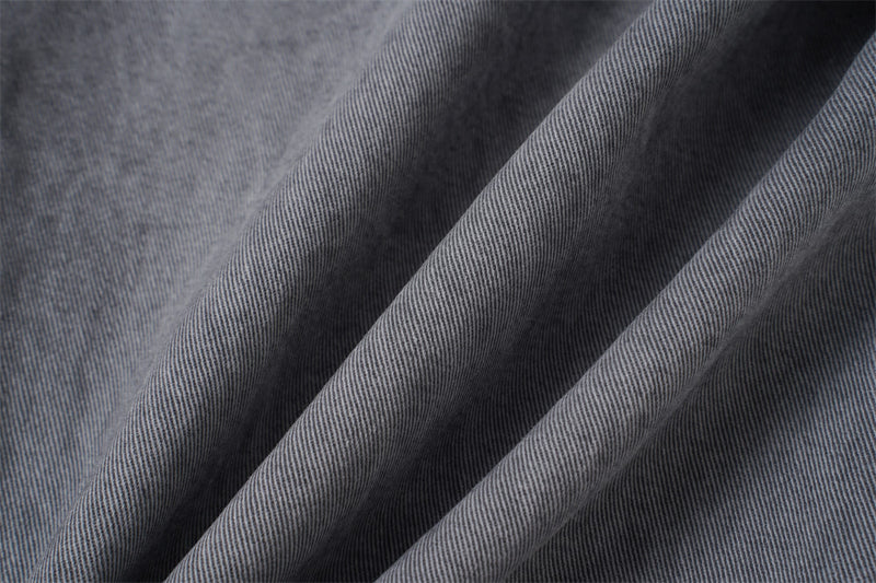 Close-up of grey denim fabric texture with soft folds