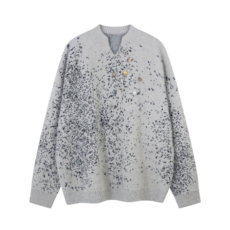 Oversized v-neck grey sweater with dark speckle jacquard knit pattern and decorative metal and shell pin cluster at chest