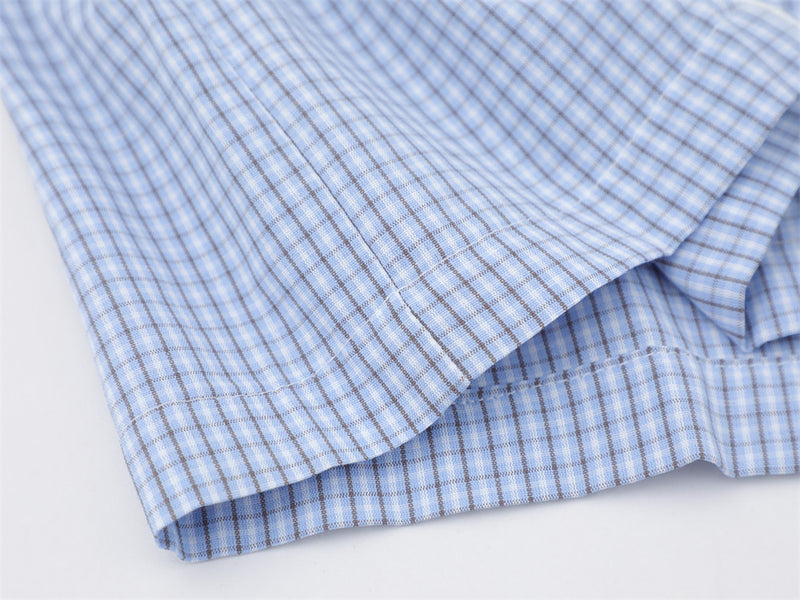 Close-up of the light blue plaid shirt hem with layered side seam detail