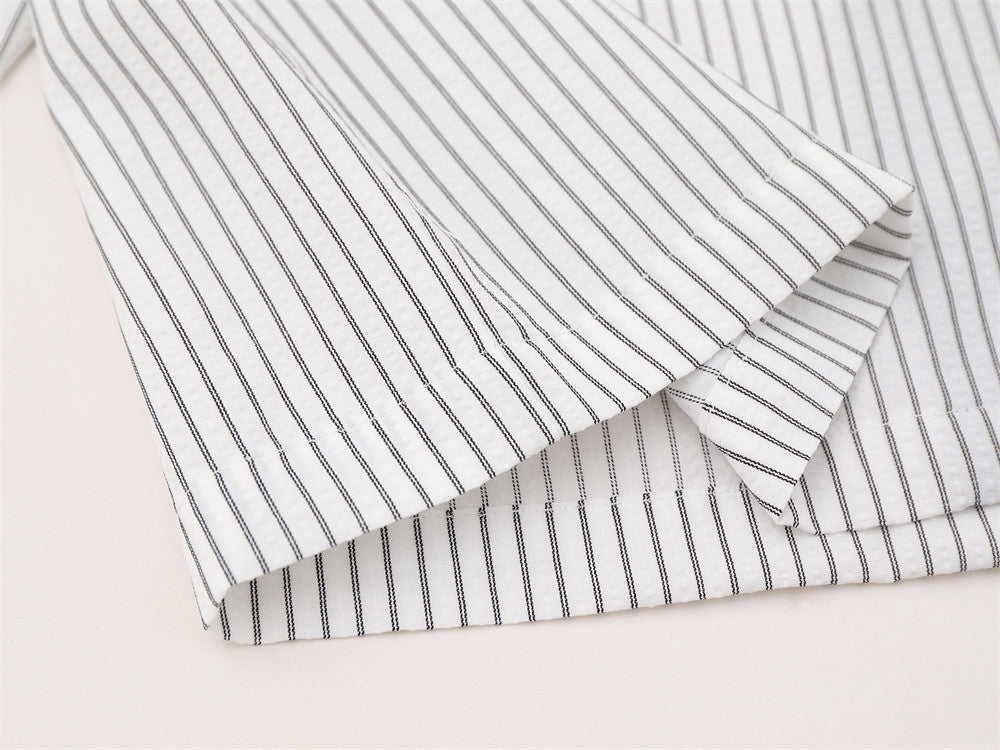 Folded striped shirt sleeves showing buttoned cuffs and fine vertical stripe pattern