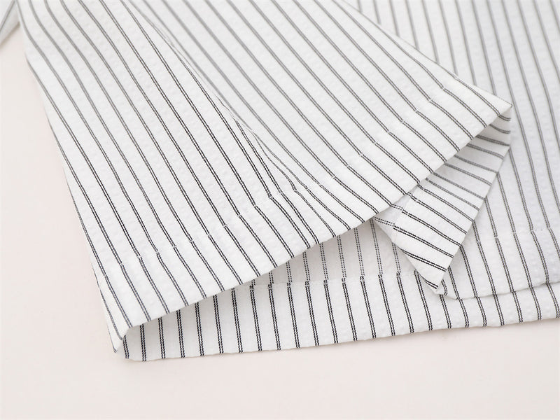 Folded striped shirt sleeves showing buttoned cuffs and fine vertical stripe pattern
