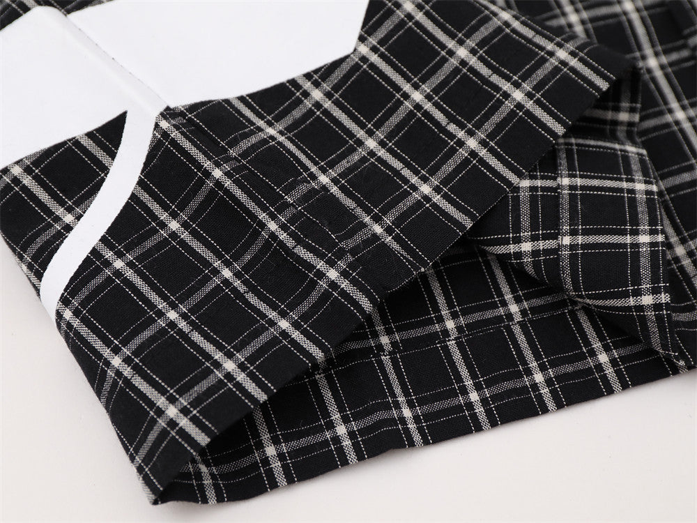 Close-up of black plaid shirt hem and sleeve cuff detail