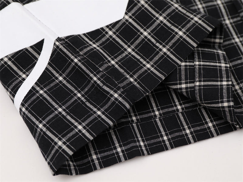Close-up of black plaid shirt hem and sleeve cuff detail