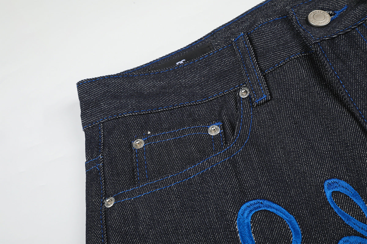 Jean baggy à jambes larges avec broderie bleue effet script et fil barbelé