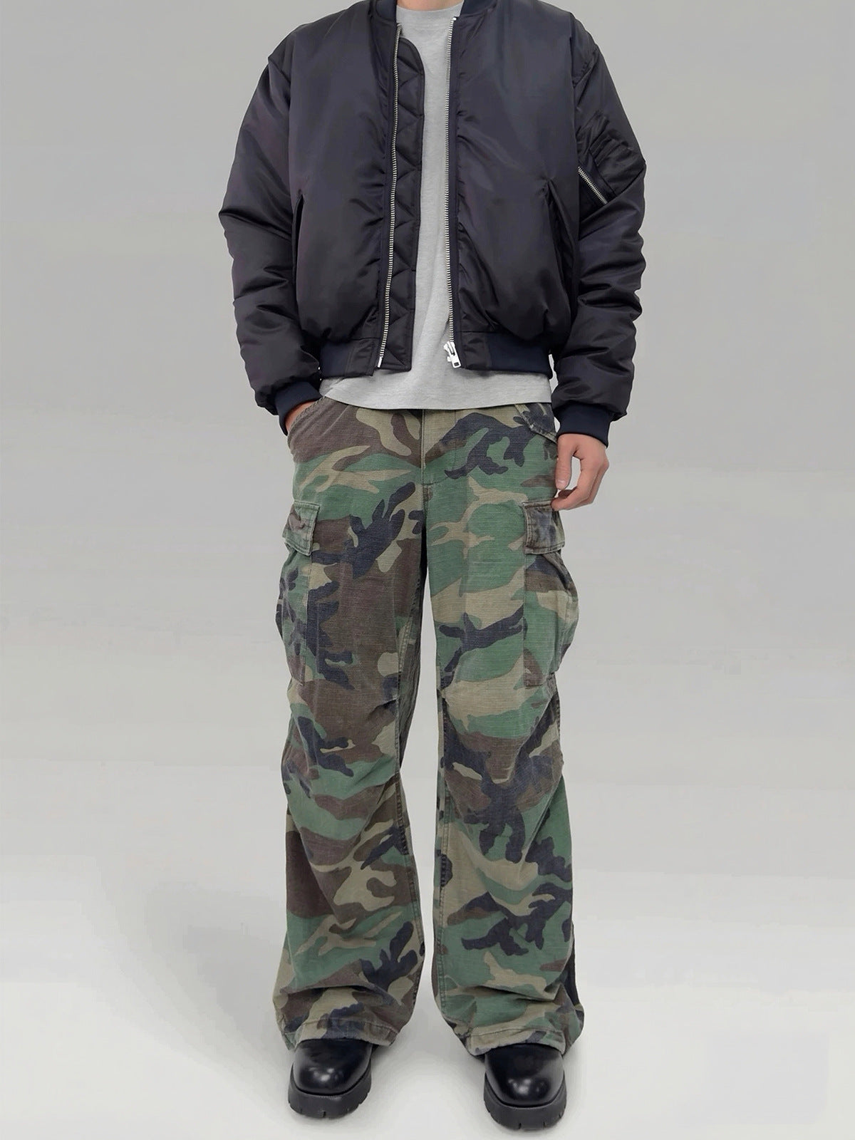 Wide-leg woodland camouflage cargo pants with multiple flap pockets, washed vintage finish, shown front and back