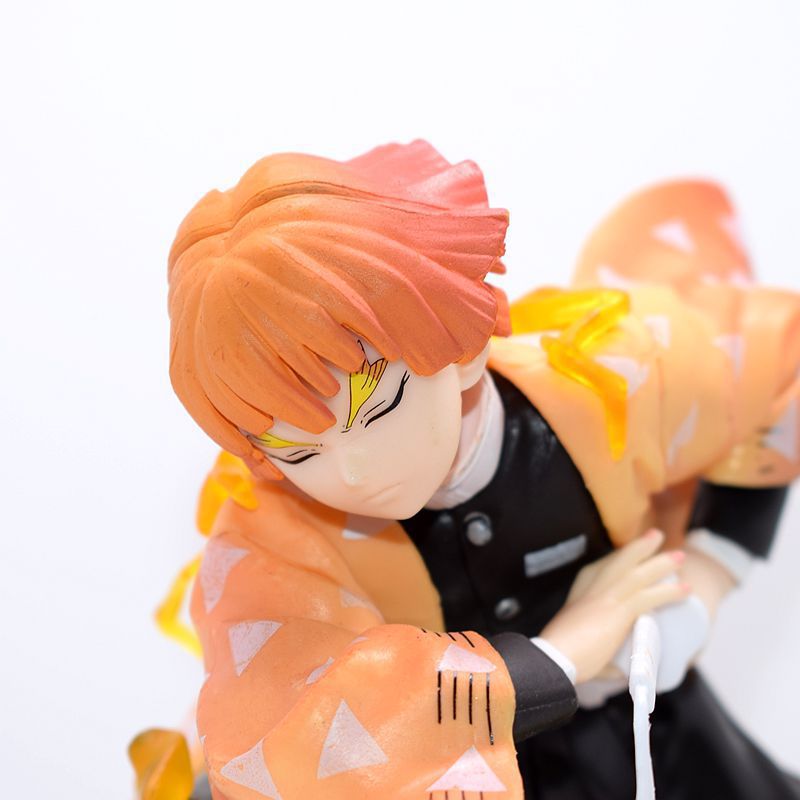 This Demon Slayer Zenitsu Agatsuma Figure is a 14.5cm high-quality PVC collectible that vividly captures the iconic character with striking orange hair, yellow streaks, a black outfit, an orange cape with white triangles, and a serious expression embodying Thunder Breathing artistry.