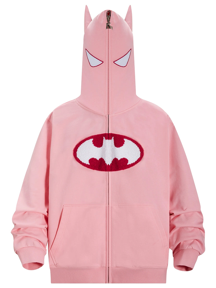 The Seakoff Batman-Inspired Hoodie, a 400GSM oversized pink zip-up sweatshirt for superhero fans, flaunts a unique bat emblem on its fabric. It includes a hood with pointed ears and face covering with eye cutouts, capturing the essence of a superhero mask.