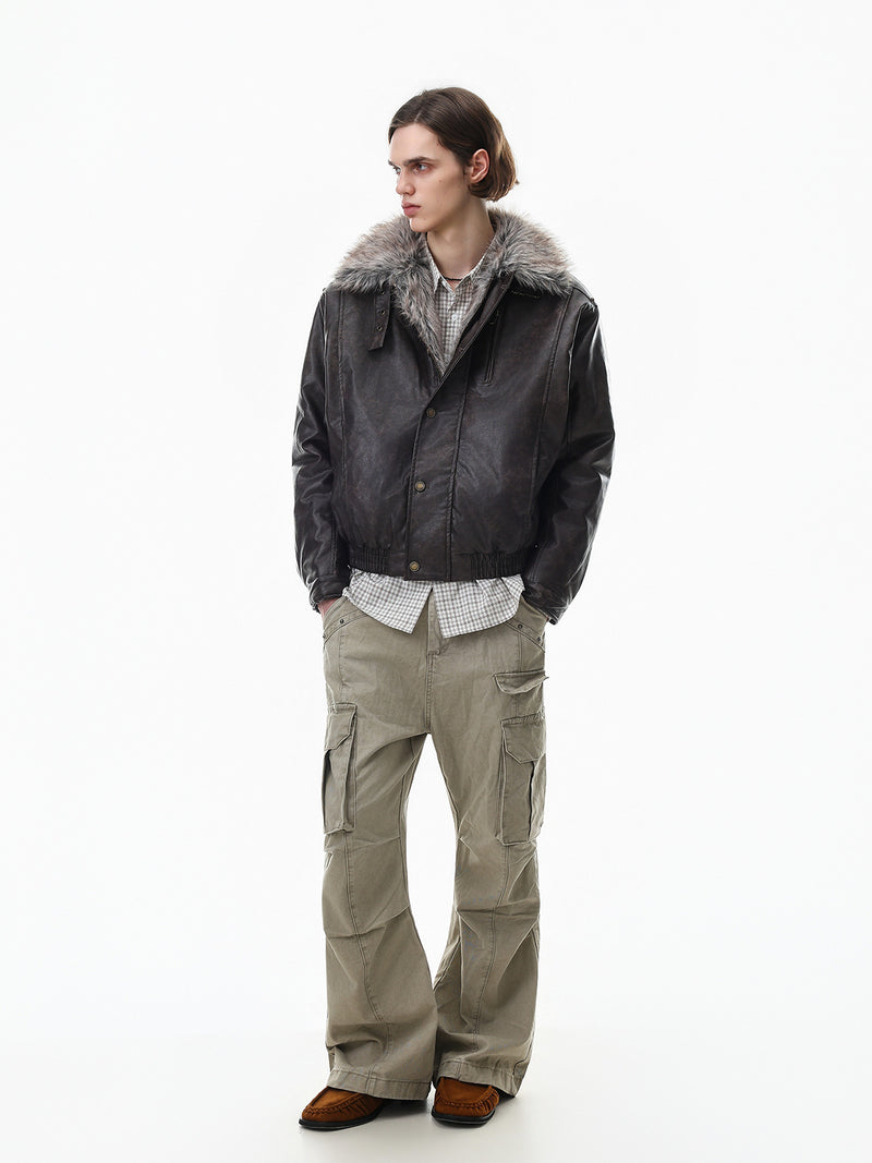 Full-length model view of a black faux leather bomber jacket with gray fur collar