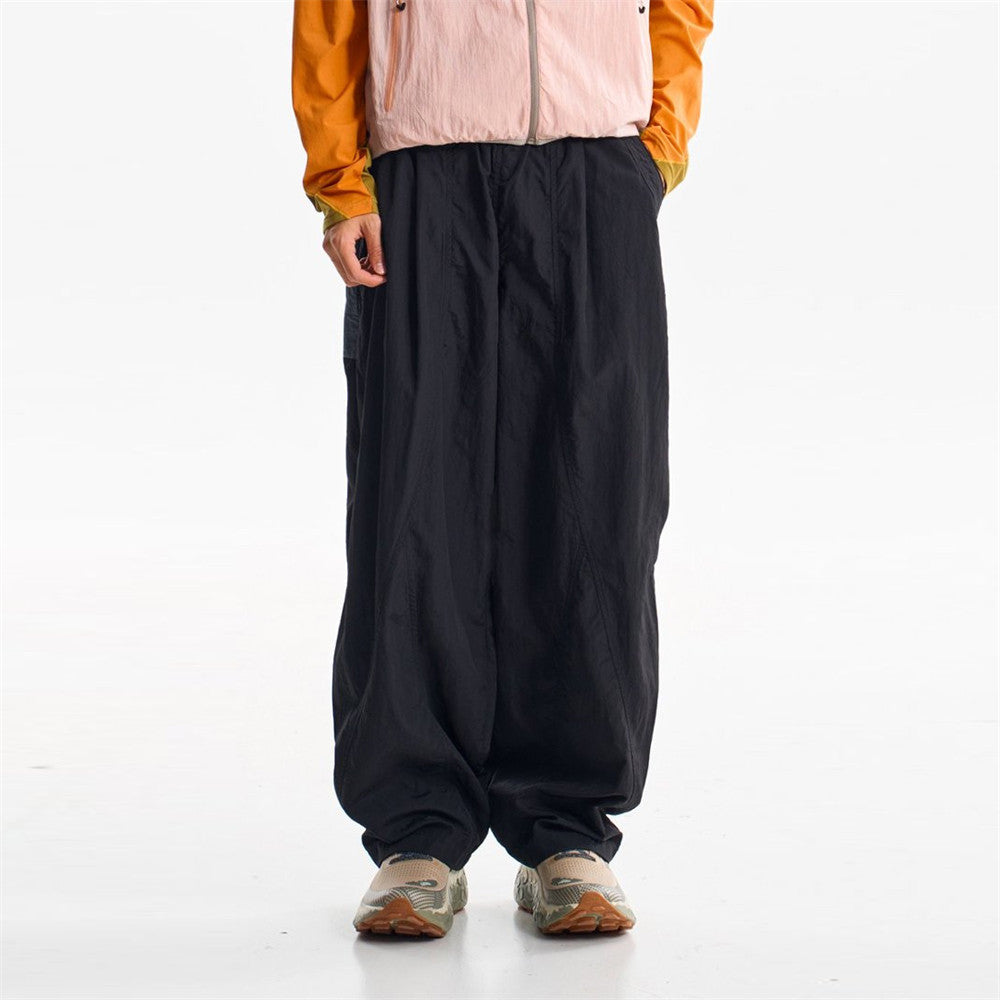 Unisex oversized wide-leg parachute pants in midnight black with elastic waist and cinched ankle cuffs