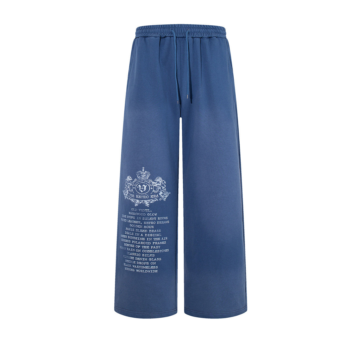 Wide-leg vintage washed sweatpants in blue with white heraldic crest and text graphic on left leg
